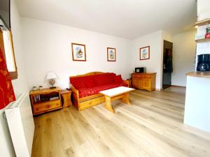 sala de estar con sofá rojo y mesa en Appartement Ski Pied de Pistes - Valfréjus, en Modane