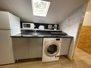 a kitchen with a washing machine and a sink at Dream Home in Calheta