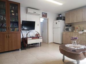 a living room with a refrigerator and a table at Red Sea Garden Apartment in Eilat