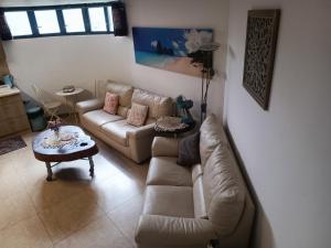 a living room with a couch and a table at Red Sea Garden Apartment in Eilat
