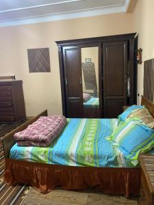 ein Schlafzimmer mit einem Bett und einem großen Spiegel in der Unterkunft Rue Mohamed khoudi El Biar in Ben ʼAknoûn