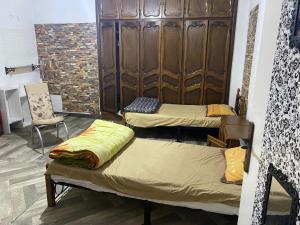 Habitación con 2 camas y silla en Rue Mohamed khoudi El Biar en Ben ʼAknoûn
