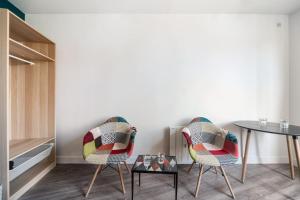uma sala de jantar com duas cadeiras e uma mesa em Beau et Cosy studio - 8min Paris em Rosny-sous-Bois