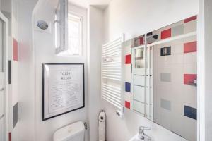 uma casa de banho com um lavatório, um WC e uma janela. em Beau et Cosy studio - 8min Paris em Rosny-sous-Bois