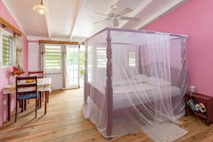 um quarto com uma cama e uma rede mosquiteira em Cabier Ocean Lodge em Crochu