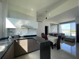 a kitchen and dining room with a table and chairs at APARTAMENTO PUERTO MADERA in Manta