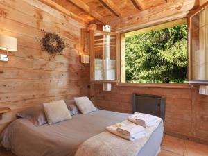 ein Schlafzimmer mit einem Bett in einem Blockhaus in der Unterkunft Auberge Les Myrtilles in Le Bosc