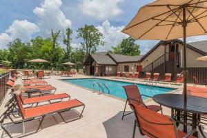 a pool with chairs and tables and an umbrella at NEW Const Sleeps 6 Pool - close to Pkwy in Pigeon Forge