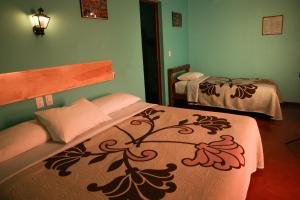 a room with two beds in a room at Hotel Las Golondrinas in Oaxaca City