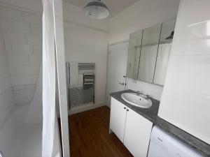 ein weißes Badezimmer mit einem Waschbecken und einem Spiegel in der Unterkunft 120 Mortimer St, Herne Bay in Kent
