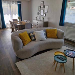 a living room with a couch and a dining room at Maison de vacances in Appenwihr
