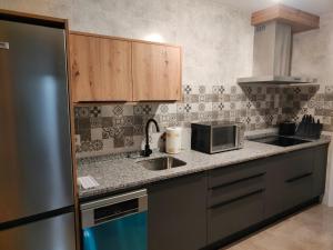 a kitchen with a sink and a microwave at Tiempo de Cerezas in Cabezuela del Valle