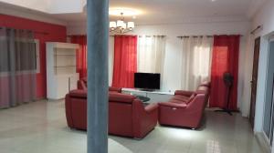 a living room with two red chairs and a television at Al jannah Bis in Somone