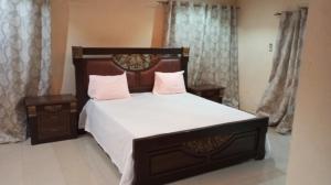 ein Schlafzimmer mit einem großen Bett mit weißer Bettwäsche und rosa Kissen in der Unterkunft Al jannah Bis in Somone