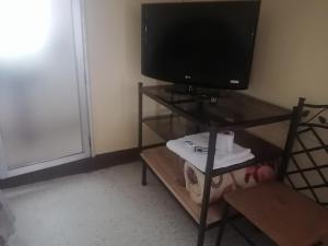 a television sitting on a stand with a table at La Mansión de las Cascadas in Chimaltenango