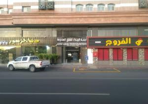 a white truck parked in front of a building at Al Baida Suites Al Salam Branch in Al Madinah
