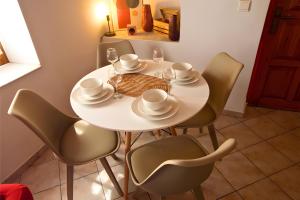 a white dining room table with chairs and glasses and a bowl at Nafplio Nook in Nafplio