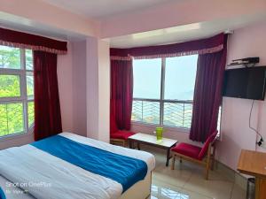 Schlafzimmer mit einem Bett, einem Schreibtisch und Fenstern in der Unterkunft Boho Stays near mall in Shimla