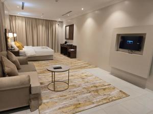 ein Wohnzimmer mit einem Sofa und einem TV an der Wand in der Unterkunft سحابة الأحلام - Dream Cloud Hotel in Dschidda