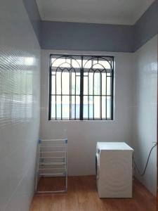 an empty room with a window and a refrigerator at Paje Home away from home in Paje
