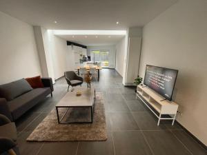 a living room with a couch and a table at Belle maison idéalement située in Mons