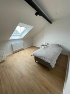 a attic bedroom with a bed and a skylight at Belle maison idéalement située in Mons