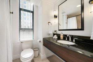 ein Badezimmer mit einem Waschbecken, einem WC und einem Spiegel in der Unterkunft Elegant & Luxury 2 Bed Suite Close to Convention Centre in Vancouver