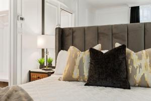 a bedroom with a large bed with pillows at Elegant & Luxury 2 Bed Suite Close to Convention Centre in Vancouver