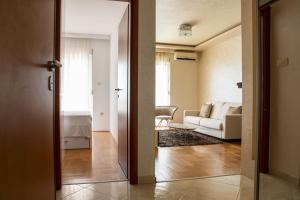 een open deur naar een woonkamer met een witte bank bij Vista Suite in Budva