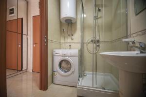 een badkamer met een wasmachine en een wastafel bij Vista Suite in Budva +13 foto's