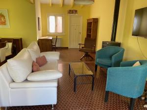 a living room with a white couch and two chairs at La Brújula - Casa Boutique in La Cumbre