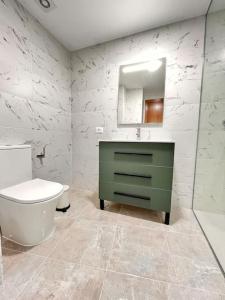 een badkamer met een groene wastafel en een toilet bij Extenso y relajante apartamento in Vilaflor