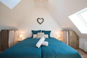 um quarto com uma cama azul com um coração na parede em LE RELAIS DES CALECHES - l'Appartement "L'aparté" 