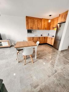 a kitchen with a table and a refrigerator at Extenso y relajante apartamento in Vilaflor