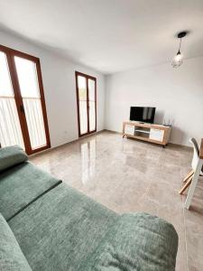 een woonkamer met een bank en een tv bij Extenso y relajante apartamento in Vilaflor