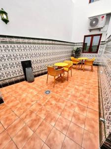 a room with chairs and tables and a tile wall at Extenso y relajante apartamento in Vilaflor