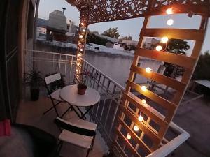 einen Balkon mit einem Tisch, Stühlen und einer Leiter in der Unterkunft "Tu refugio espacioso en el corazón de MENDOZA y el PARQUE" in Mendoza