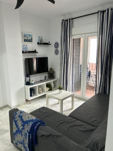 sypialnia z łóżkiem, telewizorem i stołem w obiekcie APARTAMENTO CASA AZUL w mieście Zahara de los Atunes