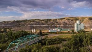 a bridge over a road with a mountain in the background at #Y2 Sage & Wildflower Yurt in Drumheller