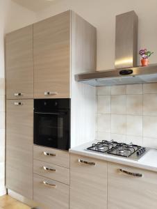 uma cozinha com armários de madeira e um forno com placa de fogão em Bel appartement dans la campagne étrusque em Vignanello