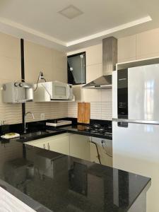 a kitchen with a black counter top and a microwave at COPACABANA RIO PRAIA 18 in Rio de Janeiro