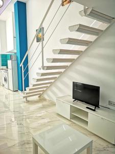 sala de estar con TV y escalera en OFIC/ESTUDIO CONIL S.A., en Conil de la Frontera