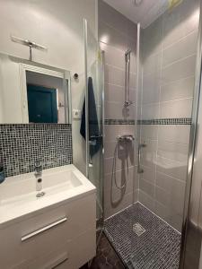 y baño con ducha, lavamanos y ducha. en Cosy appartement - La Villette, en París