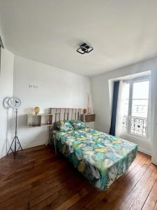 1 dormitorio con cama y ventana en Cosy appartement - La Villette, en París