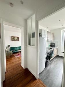 cocina con nevera blanca en una habitación en Cosy appartement - La Villette, en París