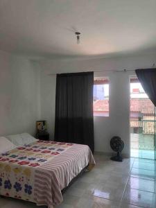 - une chambre avec un lit et 2 fenêtres dans l'établissement Excelente casa para Descanso ou Lazer, à São Pedro da Aldeia