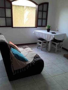 - un salon avec une table et un canapé dans l'établissement Excelente casa para Descanso ou Lazer, à São Pedro da Aldeia