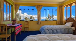 a bedroom with two beds and a large window at Amantani sol Andino in Amantani