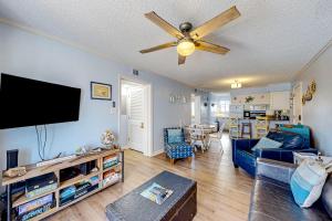 a living room with a couch and a ceiling fan at Ocean Breeze 106B in Emerald Isle