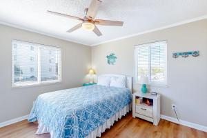 a bedroom with a bed and a ceiling fan at Ocean Breeze 106B in Emerald Isle